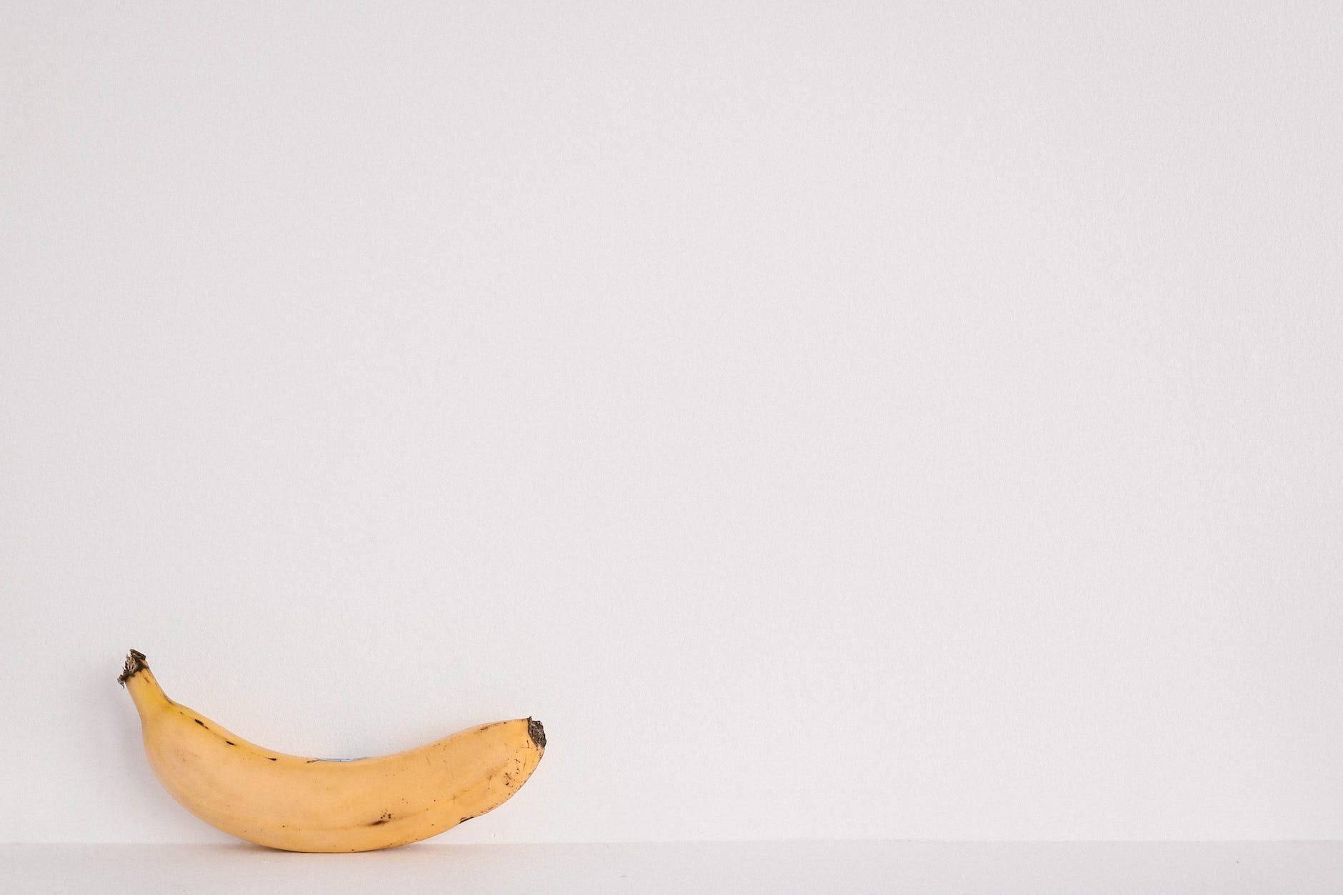 yellow banana fruit on white surface