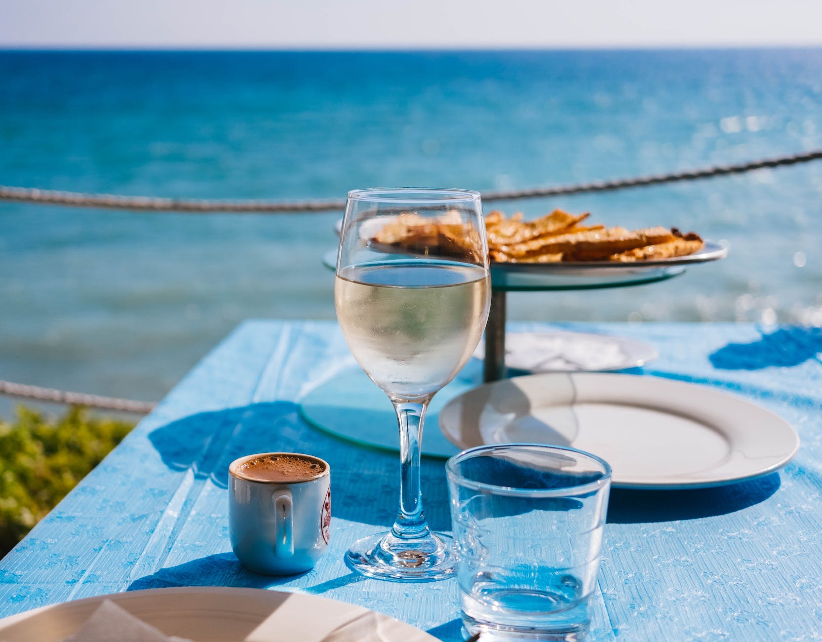 clear drinking glass beside plate on table far from water close up photography