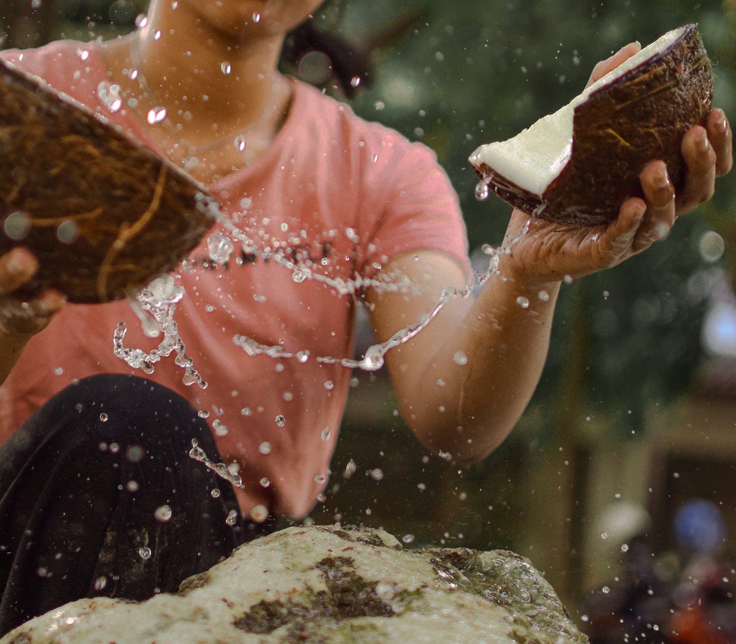 photo of woman cracking coconut shells