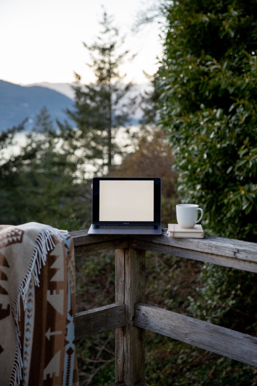 laptop with empty screen and cup of hot drink