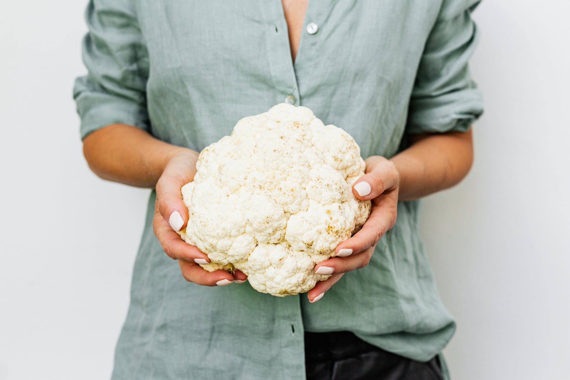 person holding cauliflower