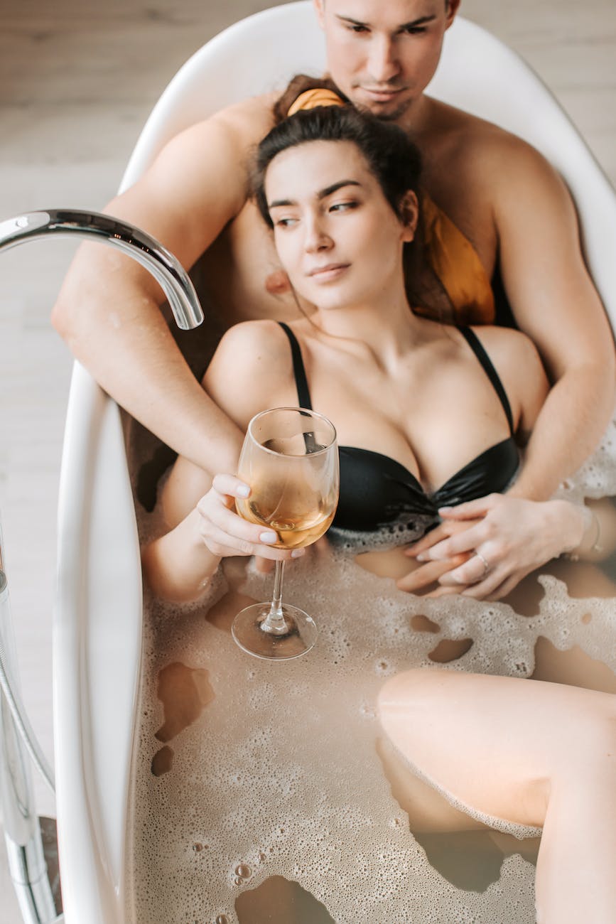 woman in black bikini bathing in white bathtub