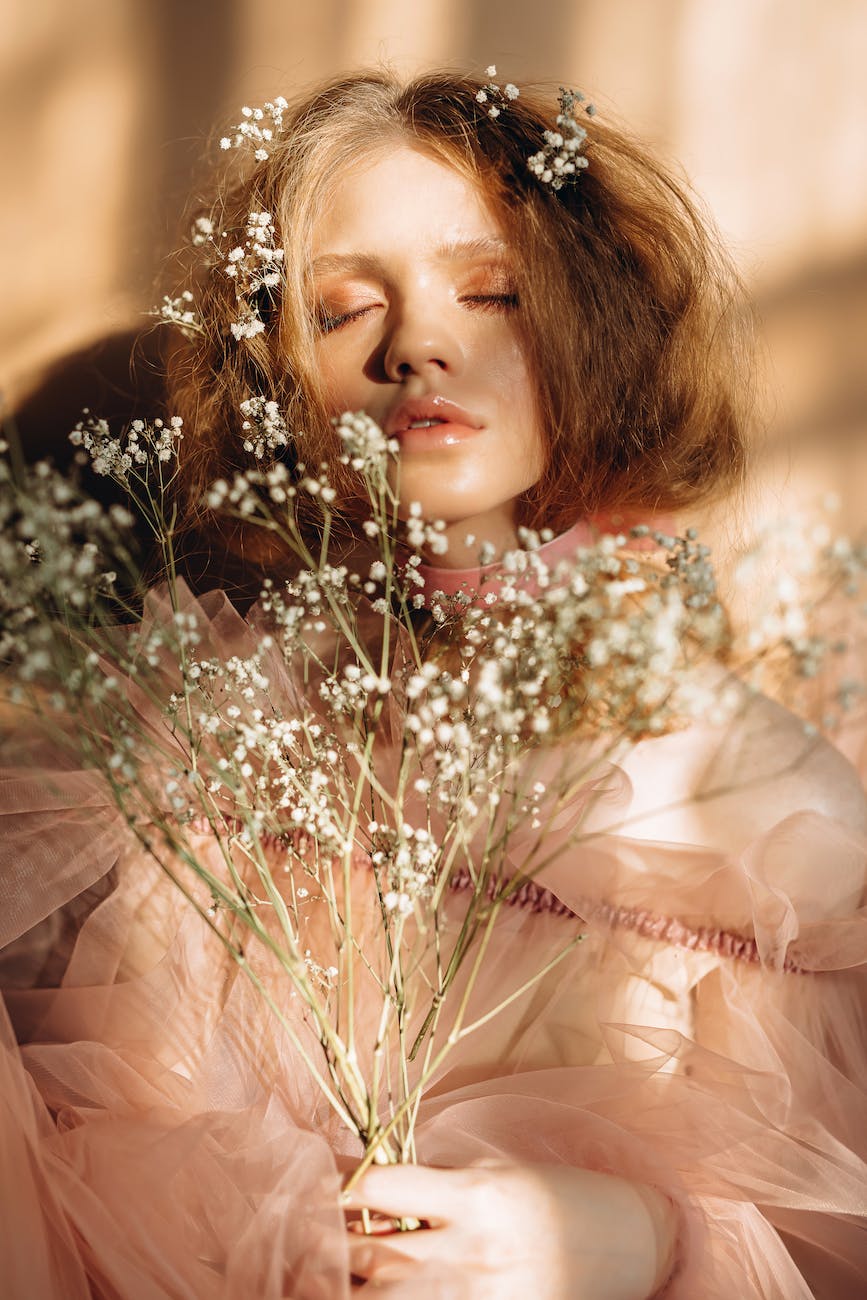 woman with her eyes closed holding buckwheat flowers