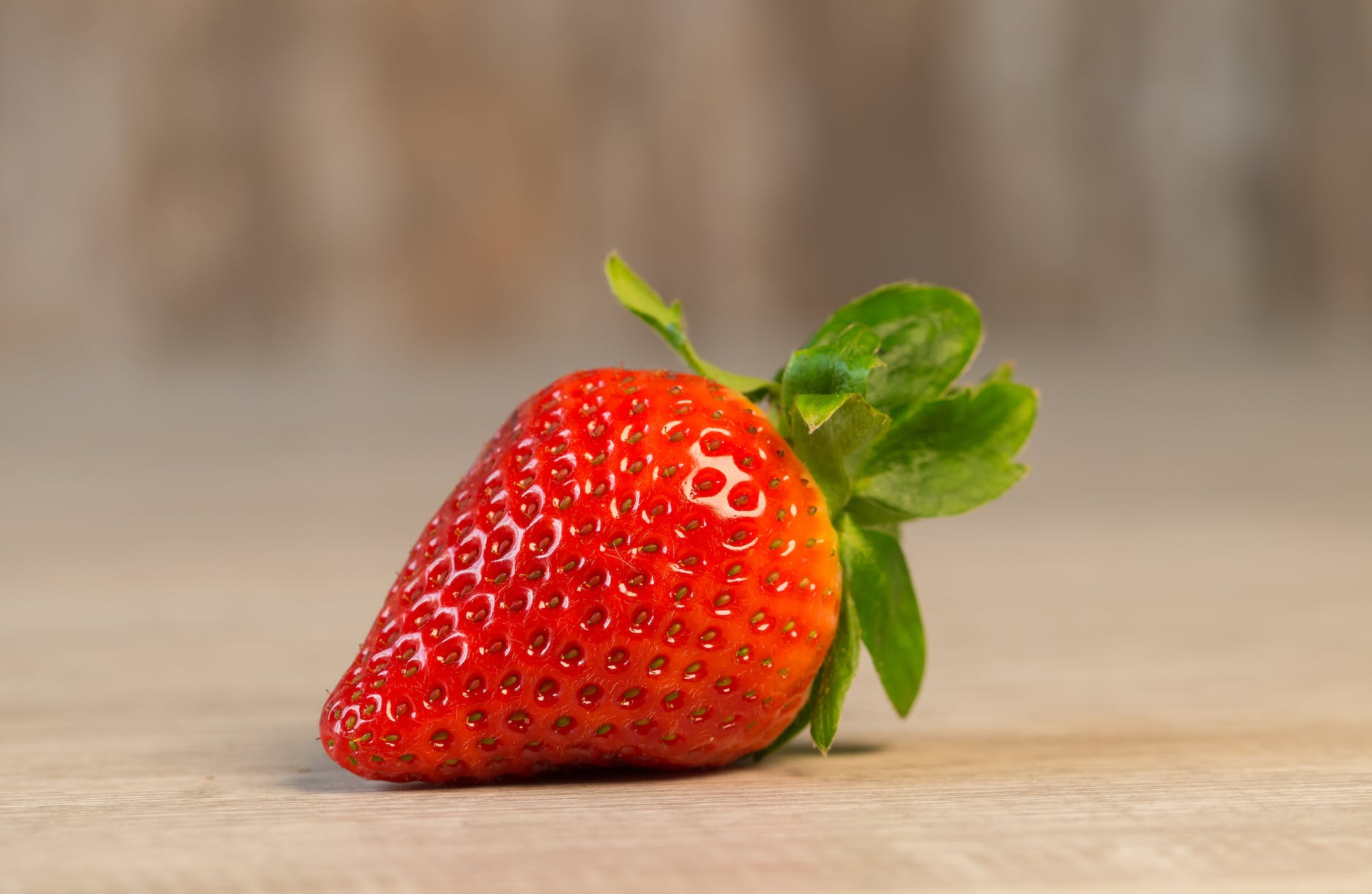 strawberry fruit on brown wooden surface